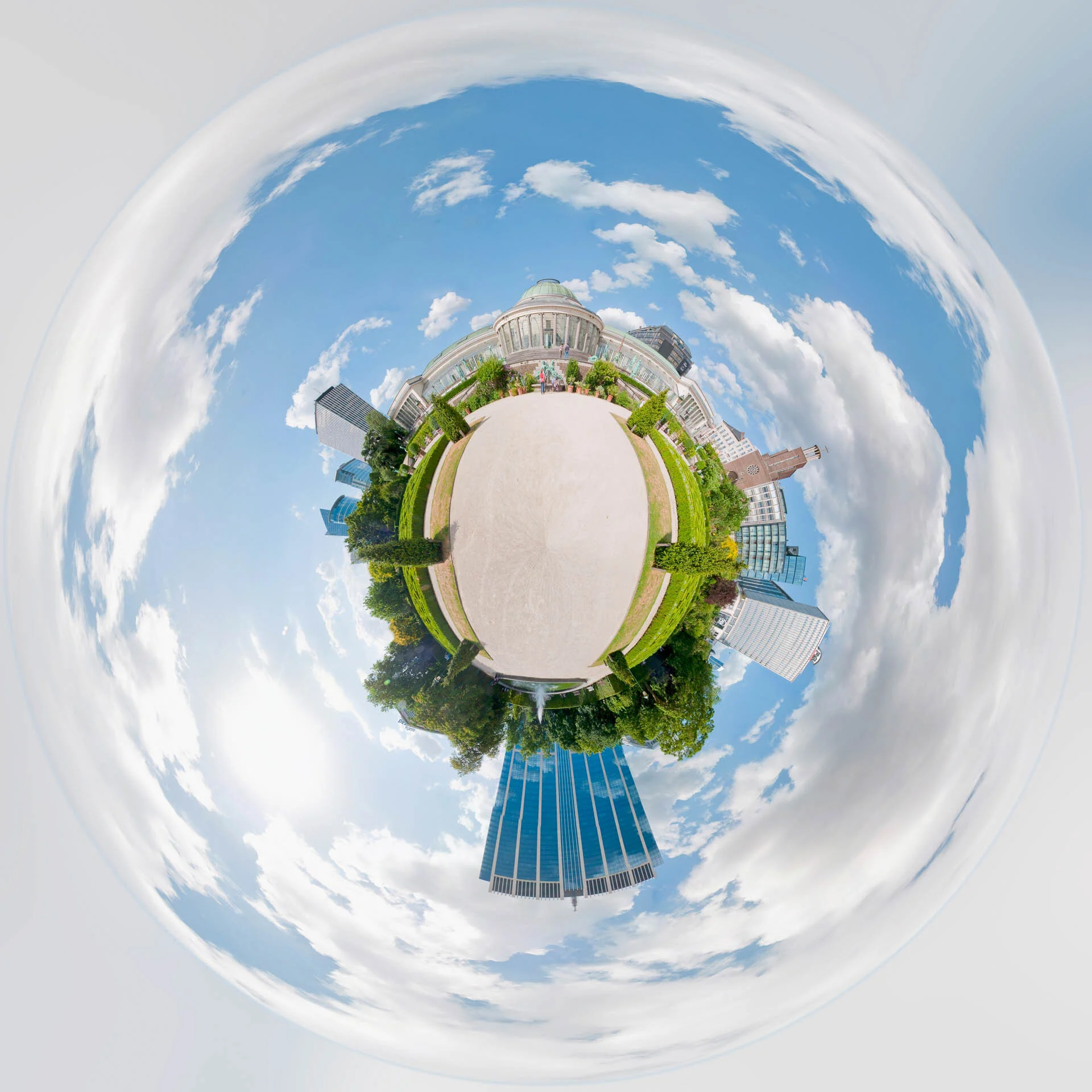 Mini-planète du parc du Botanique à Bruxelles, avec ses allées, ses jardins et ses bâtiments sous un ciel bleu.