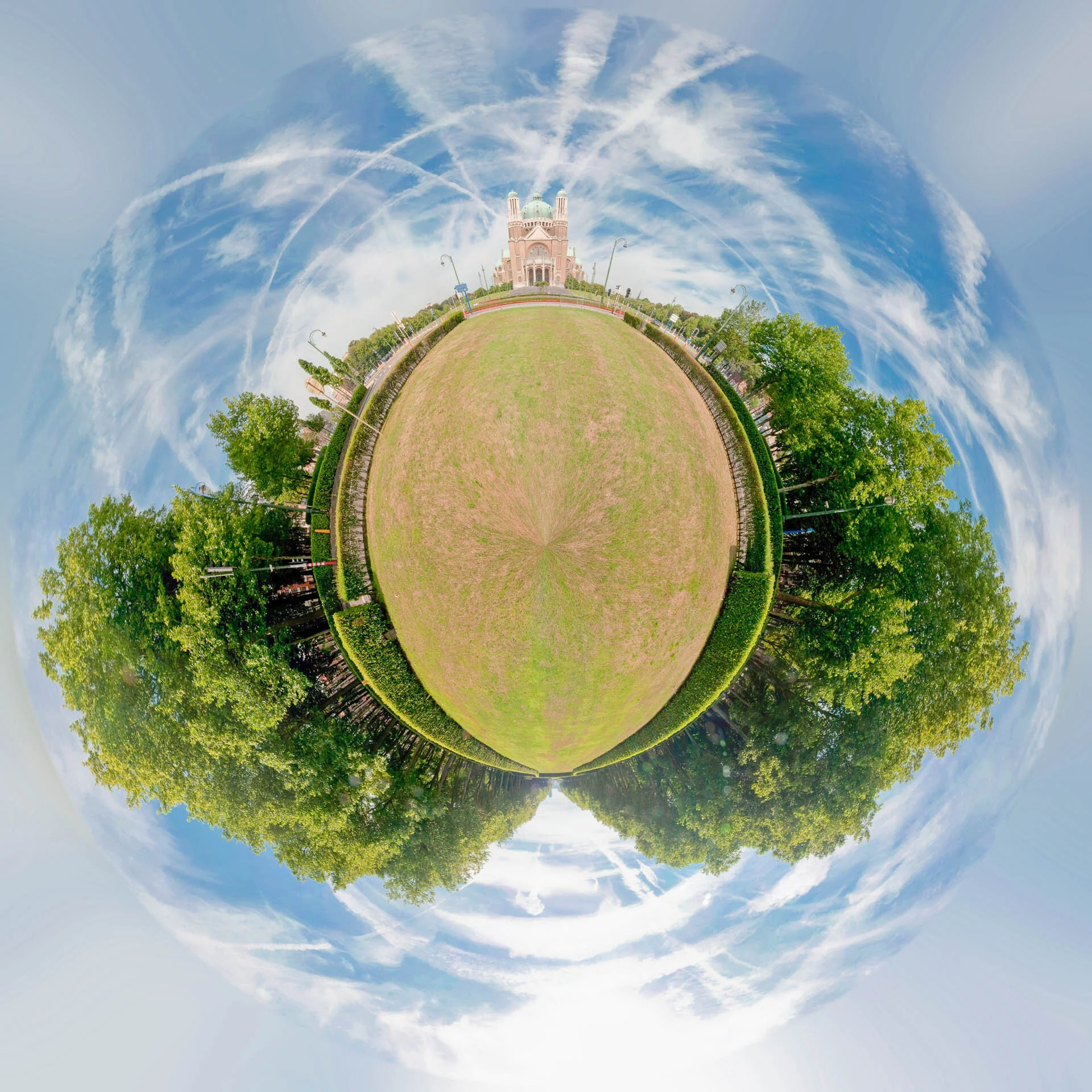 Mini-planète de la basilique de Koekelberg à Bruxelles, avec une vaste pelouse entourée d’arbres.