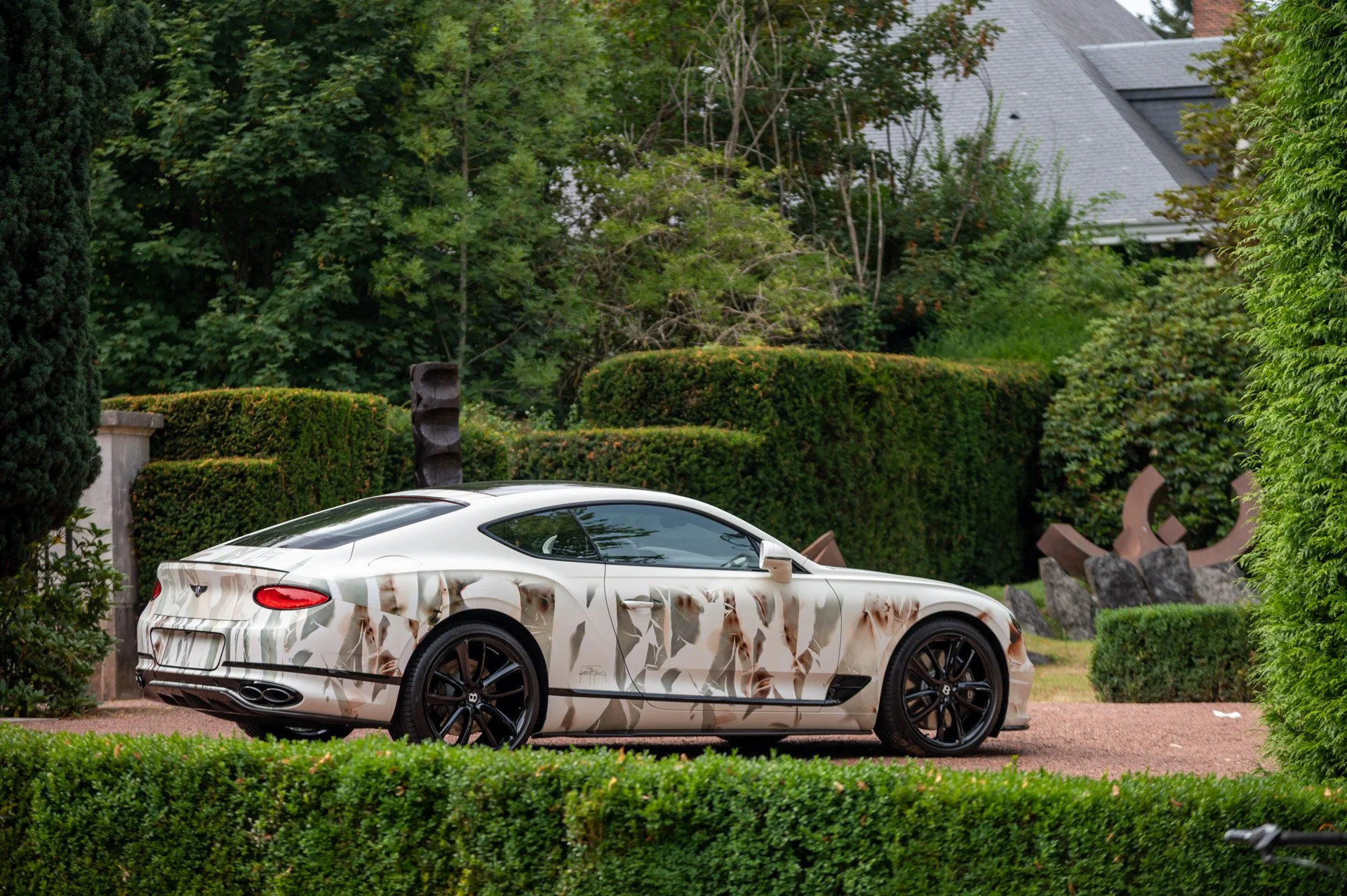 Une Bentley Continental GT décorée de motifs artistiques, garée dans le jardin de la Villa Empain lors de la soirée Art On Cars.