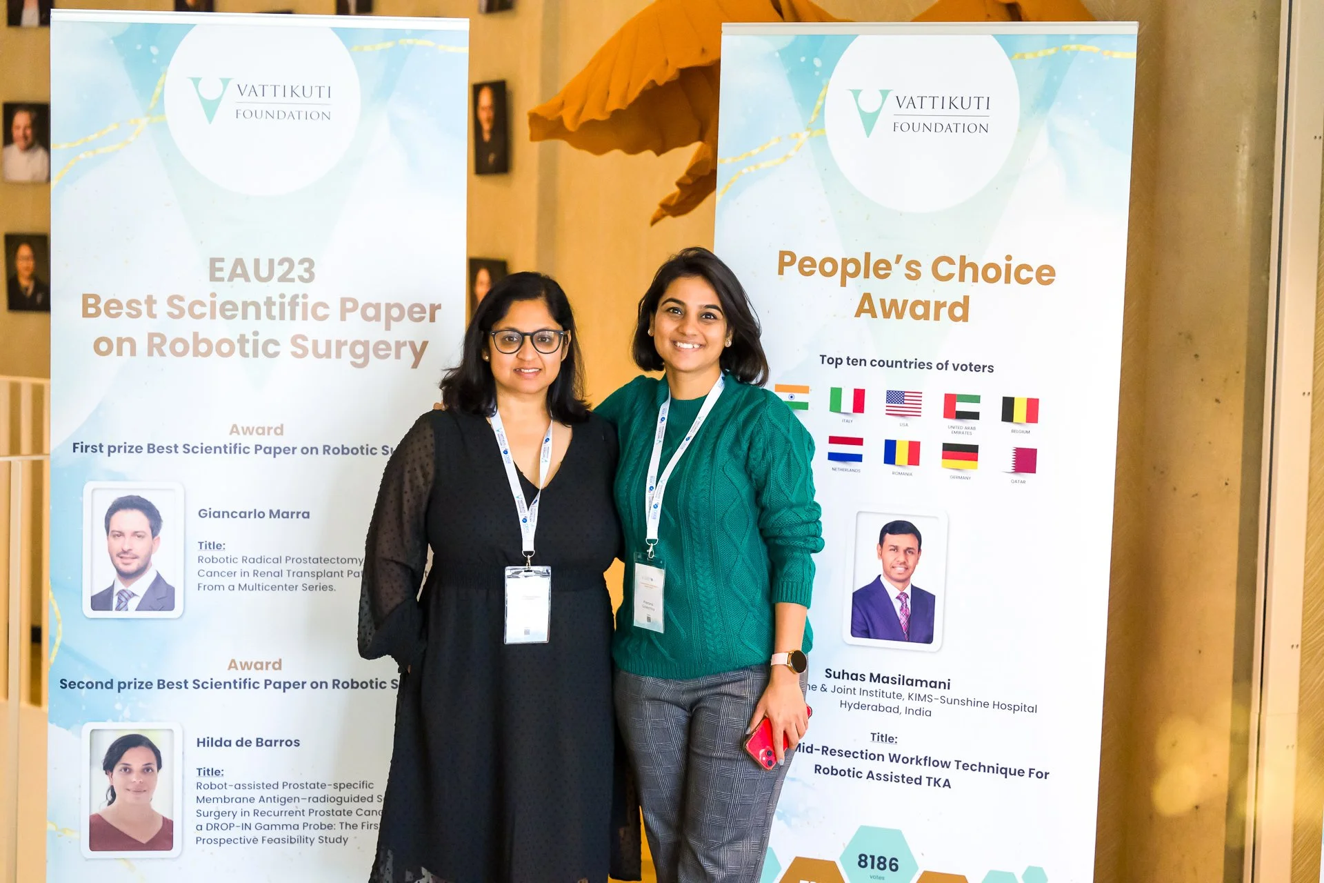 Deux femmes devant les panneaux de prix scientifiques de la Vattikuti Foundation consacrés à la chirurgie robotique.