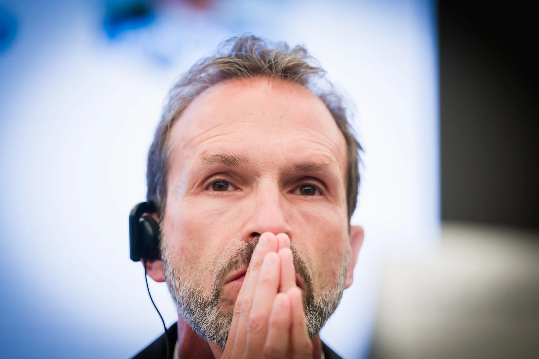 Un homme pensif avec un casque audio, photographié pendant une conférence dans le quartier européen à Bruxelles.
