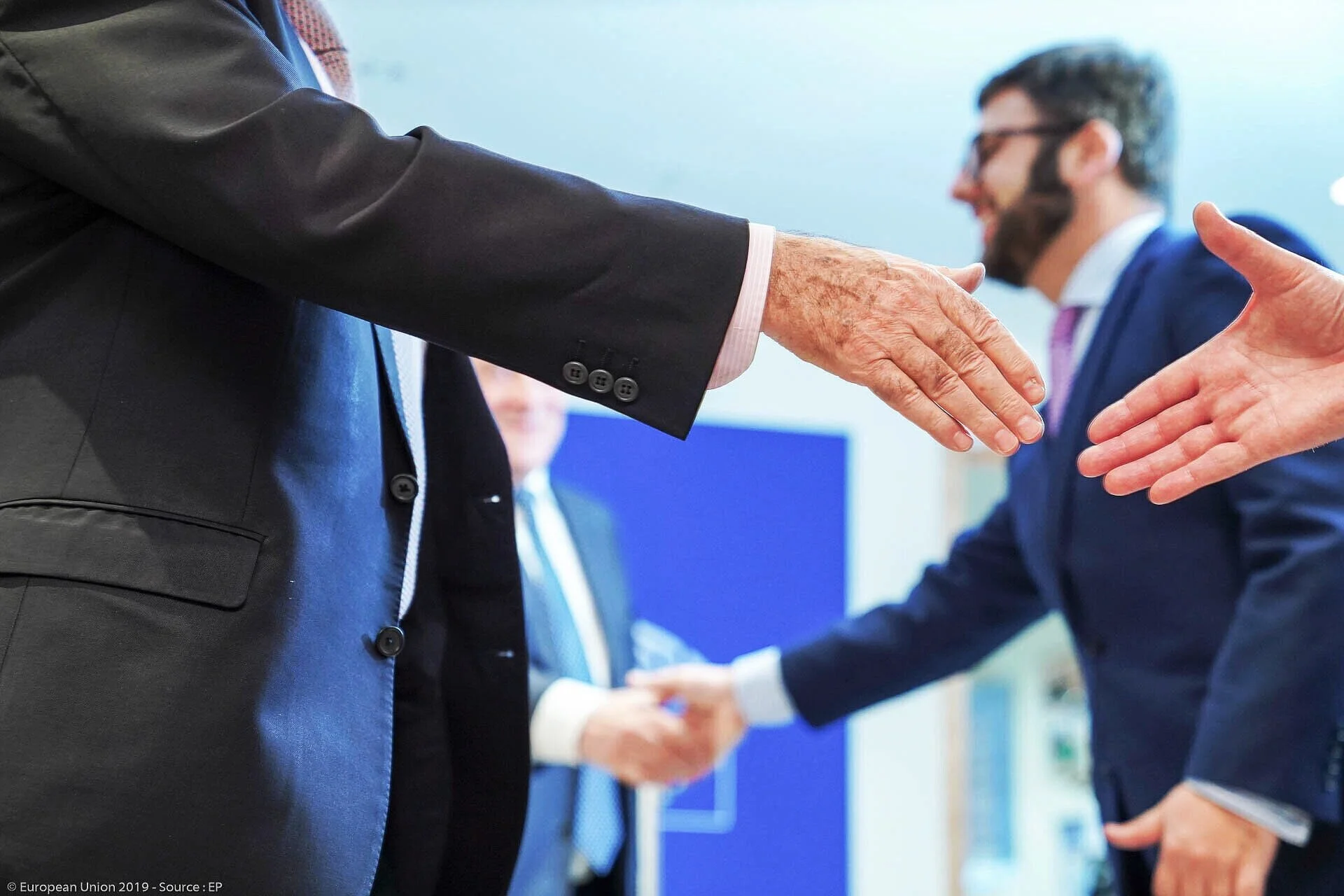 Gros plan sur deux mains tendues pour une poignée de main lors d’une rencontre professionnelle.