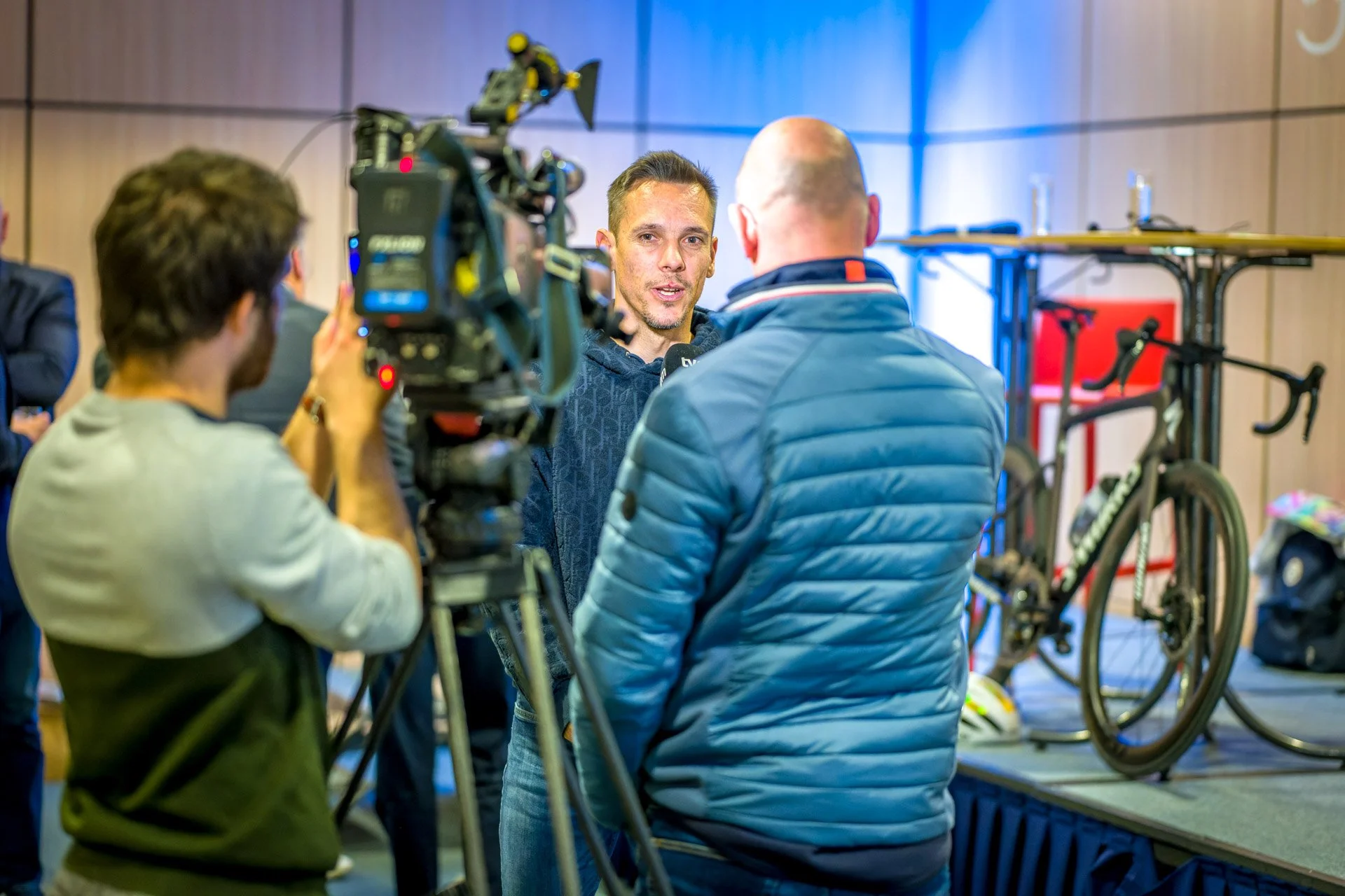 Interview en cours avec un homme devant une caméra, un vélo en arrière-plan.
